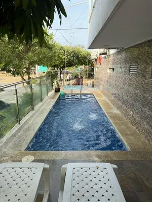 a swimming pool with blue water in a building at Apartahotel Eden Coveñas in Coveñas