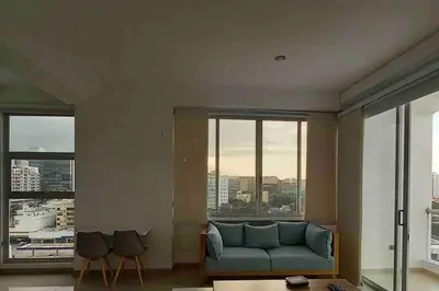 a living room with a blue couch and large windows at Amazing views in Barranquilla in Barranquilla