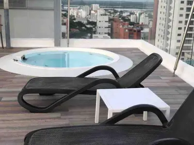 a chair and a table and a pool on a building at Amazing views in Barranquilla in Barranquilla