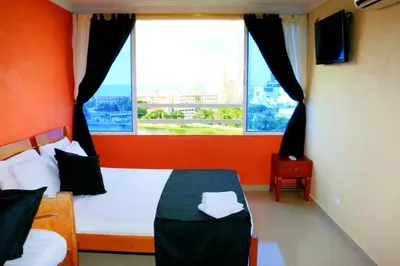 a bedroom with a bed and a large window at Studio Apartment E11C Near The Sea With Pool in Cartagena de Indias