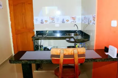 a kitchen with a counter with a sink and a stool at Studio Apartment E11C Near The Sea With Pool in Cartagena de Indias