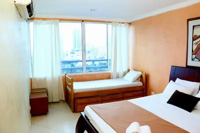 a hotel room with two beds and a window at Apartment 1C11 Near The Sea With Pool in Cartagena de Indias