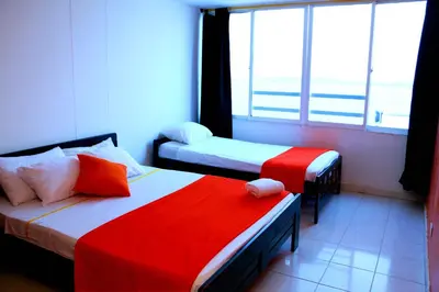a room with two beds with red and white sheets at Apartment 1C19 Close To The Sea With Pool in Cartagena de Indias