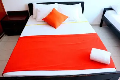 a bed with a red blanket on top of it at Apartment 1C19 Close To The Sea With Pool in Cartagena de Indias