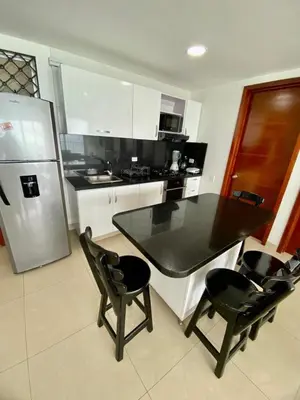 a kitchen with a table and chairs and a refrigerator at Apartment al-1 facing the sea with pool and Wifi in Cartagena de Indias