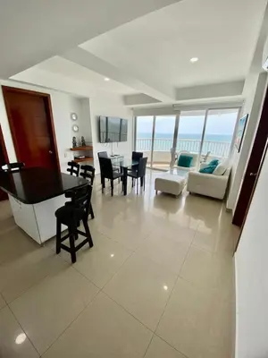 a living room with a dining table and a living room with the ocean at Apartment al-1 facing the sea with pool and Wifi in Cartagena de Indias
