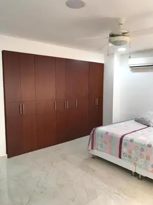 a bedroom with a bed and wooden cabinets at 3MR8 Duplex Apartment Close To The Sea With Pool in Cartagena de Indias