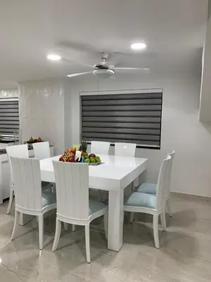 a white table and chairs with a bowl of fruit on it at 3MR8 Duplex Apartment Close To The Sea With Pool in Cartagena de Indias
