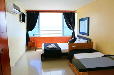 a hotel room with two beds and a window at Studio Apartment E19C Close To The Sea And Pool in Cartagena de Indias