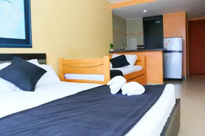 a bedroom with two beds and a kitchen with a refrigerator at Studio Apartment E19C Close To The Sea And Pool in Cartagena de Indias