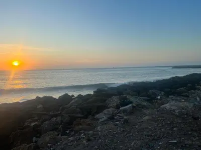 a sunset over the ocean with a group of rocks at Exquisite apartment in El Laguito Cartagena in Cartagena de Indias