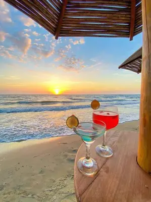 two glasses of wine sitting on a table on the beach at Suite privada frente al mar, Tolú in San Silvestre