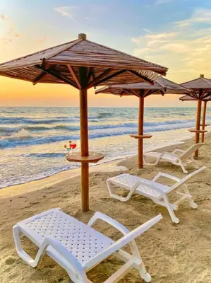 a group of chairs and umbrellas on a beach at Suite privada frente al mar, Tolú in San Silvestre