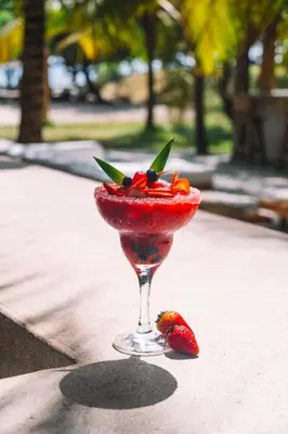 a drink in a martini glass with fruit in it at Hotel Rosario de Mar by Tequendama in Isla Grande