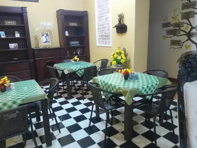 a restaurant with tables and chairs on a checkered floor at hotel san nicolas colonial in Barranquilla