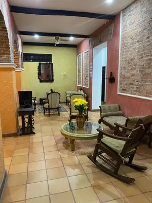 a living room with chairs and a table at hotel san nicolas colonial in Barranquilla