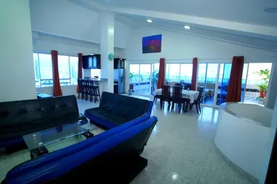 a living room with a blue couch and a dining room at Apartamentos Bacanos in Cartagena de Indias