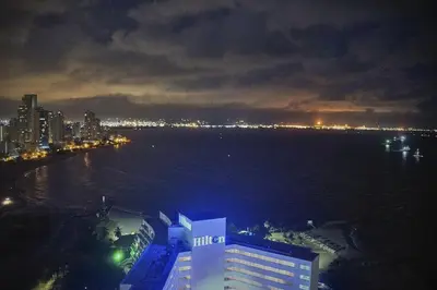 a view of the water and a city at night at Apartamentos Bacanos in Cartagena de Indias