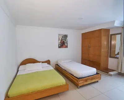 a bedroom with a bed and a wooden cabinet at Apartamentos Bacanos in Cartagena de Indias