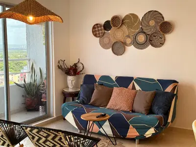 a living room with a blue couch and plates on the wall at Boho style house in Cartagena de Indias