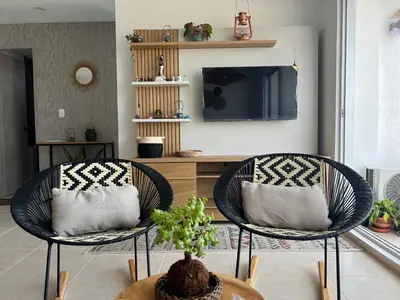 a living room with two chairs and a tv at Boho style house in Cartagena de Indias