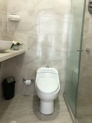 a bathroom with a toilet and a glass shower at Hermoso Apartamento en Caribe Campestre in Coveñas