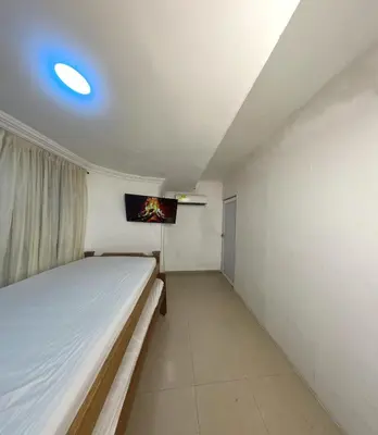 a bedroom with a bed and a tv on the wall at Hostal Viva Mar in Cartagena de Indias
