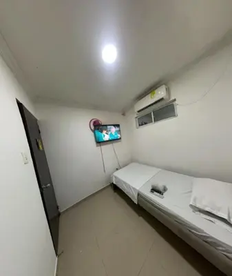 a small room with a bed and a tv at Hostal Viva Mar in Cartagena de Indias