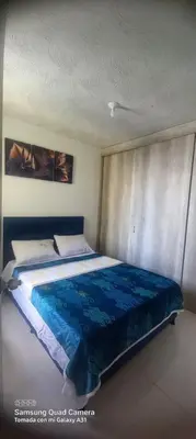 a bedroom with a large bed with a blue blanket at Apartamento Amoblado Cartagena in Cartagena de Indias