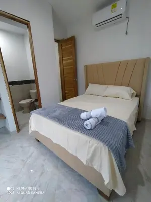 a bedroom with a bed with two towels on it at cabañas Brisas y Perla by AMAUNA in Moñitos