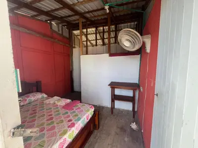 a small room with a bed and a table at Hostal Paraiso in Isla Mucura