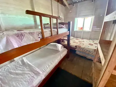a room with two bunk beds in a cabin at Hostal Paraiso in Isla Mucura