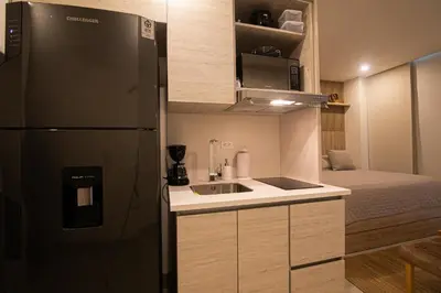 a small kitchen with a refrigerator and a bed at Apartamento en Morros Zoe con acceso directo al mar en Cartagena in Cartagena de Indias