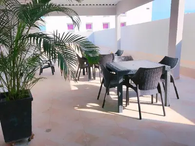 a patio with tables and chairs and a potted plant at Hotel Suite Continental in Barranquilla