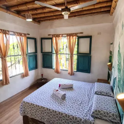 a bedroom with a bed in a room with windows at Eco-Hotel Chevere Beach in Puebloviejo