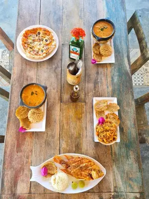 a wooden table with plates of food on it at Eco-Hotel Chevere Beach in Puebloviejo