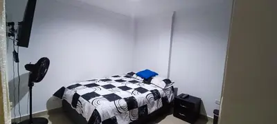 a bedroom with a black and white bed and a spotlight at Apto los Almendros in Cartagena de Indias