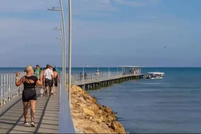 a group of people walking on a pier near the ocean at Don Mathias # 2, Coveñas - Apartamento in Coveñas