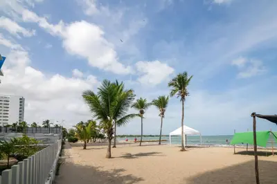 a sandy beach with palm trees and the ocean at Don Mathias # 2, Coveñas - Apartamento in Coveñas