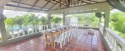 a room with a table and chairs on a balcony at Extraordinaria Casa Finca Piscina AA in Sabanalarga