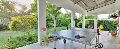 a ping pong table on the porch of a house at Extraordinaria Casa Finca Piscina AA in Sabanalarga