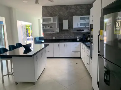 a kitchen with white cabinets and a black refrigerator at Casa Mandalay hotel in Juan de Acosta
