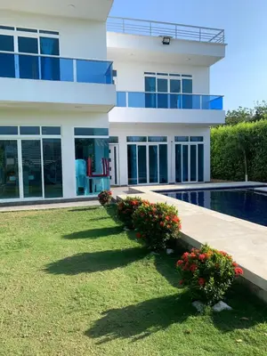 a house with a swimming pool in front of it at Casa Mandalay hotel in Juan de Acosta