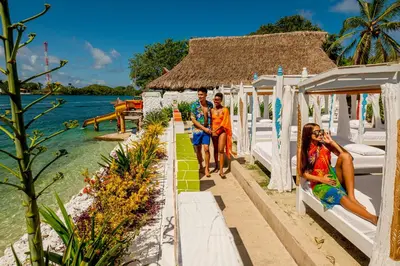 a group of three people walking down a resort walkway at Hotel Isla Lizamar in Isla Grande