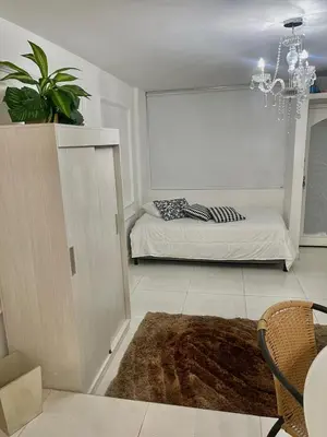 a living room with a bed and a chandelier at Alojamiento vacacional en Bocagrande Cartagena in Cartagena de Indias