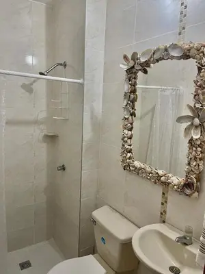 a bathroom with a toilet and a sink and a mirror at Alojamiento vacacional en Bocagrande Cartagena in Cartagena de Indias