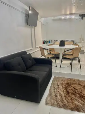 a living room with a black couch and a table at Alojamiento vacacional en Bocagrande Cartagena in Cartagena de Indias