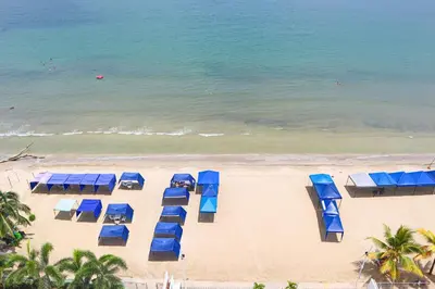 an overhead view of a beach with blue umbrellas at Mágico Apartamento Frente al Mar 3 Habitaciones PV82 in Coveñas