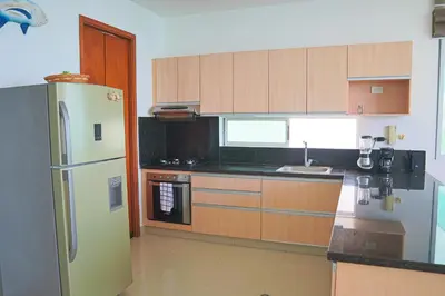 a kitchen with wooden cabinets and a refrigerator at Mágico Apartamento Frente al Mar 3 Habitaciones PV82 in Coveñas