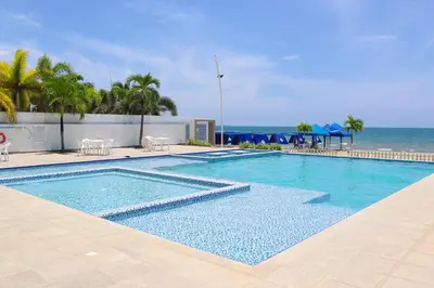 a swimming pool with the ocean in the background at Mágico Apartamento Frente al Mar 3 Habitaciones PV82 in Coveñas